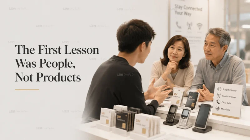 Young mobile phone seller listening to a customer at a SIM card retail counter